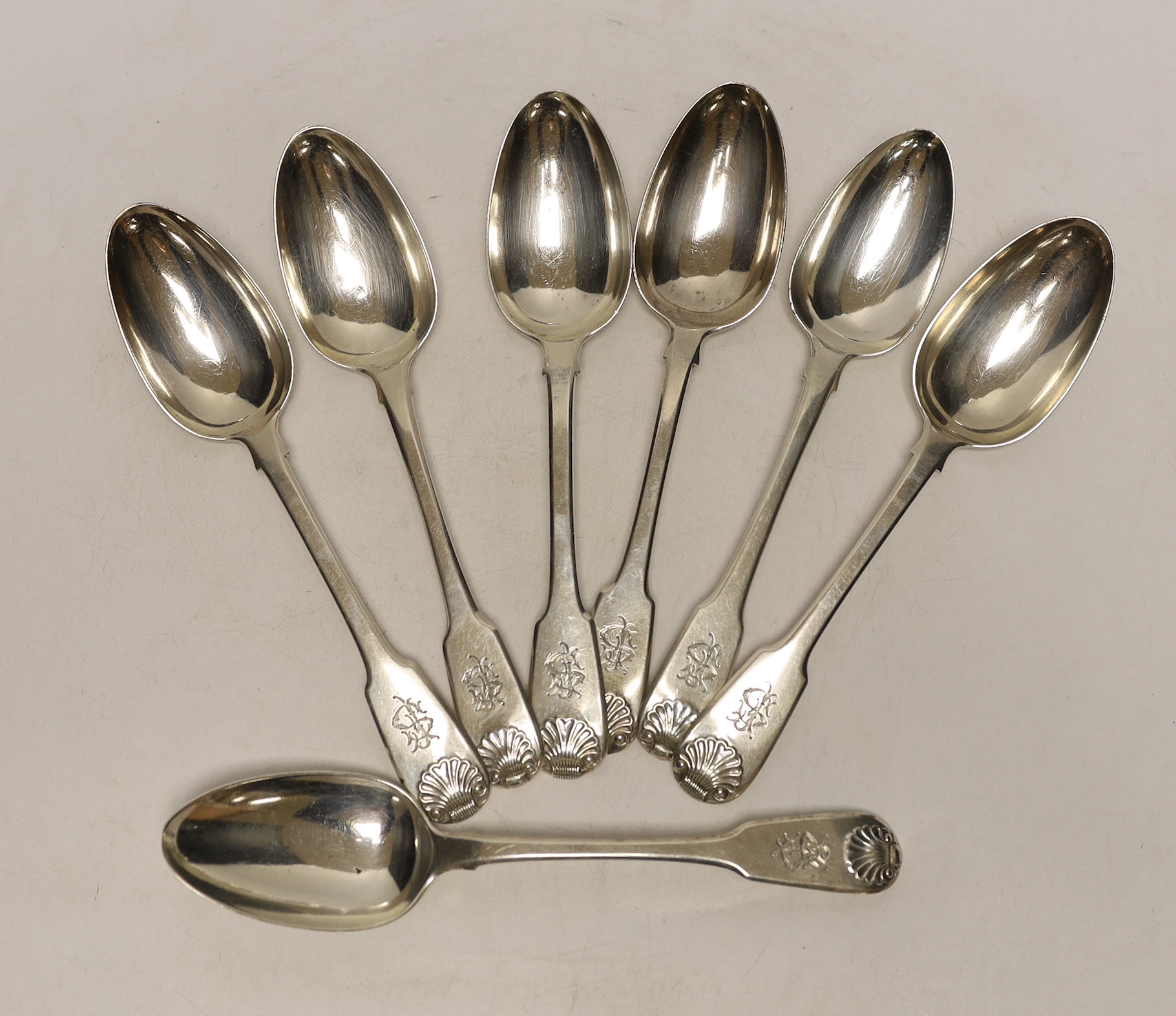 A harlequin set of seven early 19th century silver fiddle and shell pattern table spoons, various date and makers, 18.7oz.